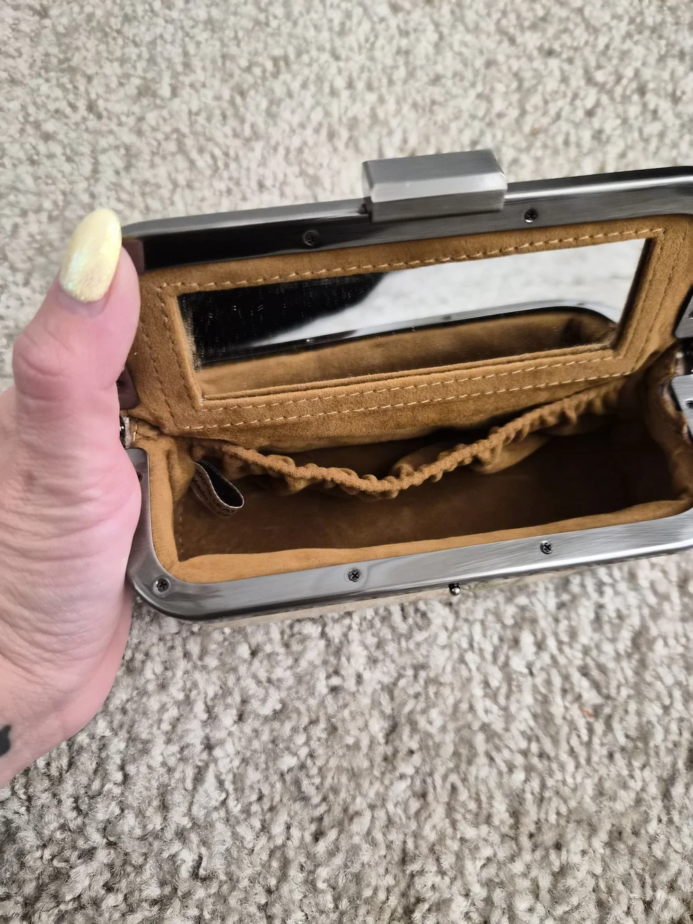 This is a Patricia Nash kiss-lock frame clutch with a built-in mirror